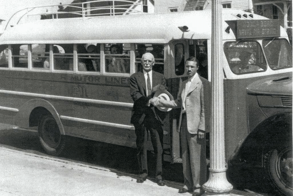 Mr. Pulsipher stand with another gentleman in front of a bus - black and white photo